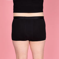 Achteraanzicht van de zwarte NIKKI menstruatieboxershort van Moi et Marie, met bedekkende pasvorm en korte pijpjes.