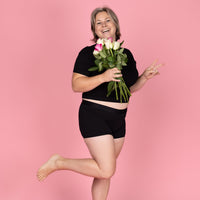 Model draagt de zwarte NIKKI menstruatieboxershort van Moi et Marie met korte pijpjes en een comfortabele aansluitende pasvorm.