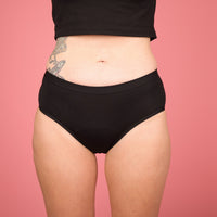 Vooraanzicht van de zwarte MARIE Daily menstruatieslip van Moi et Marie, gedragen door een model.