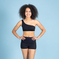 Model draagt de zwarte ZAYA menstruatiezwemboxershort van Moi et Marie, een comfortabele zwemshort waarmee je tijdens je menstruatie kunt zwemmen zonder tampon.